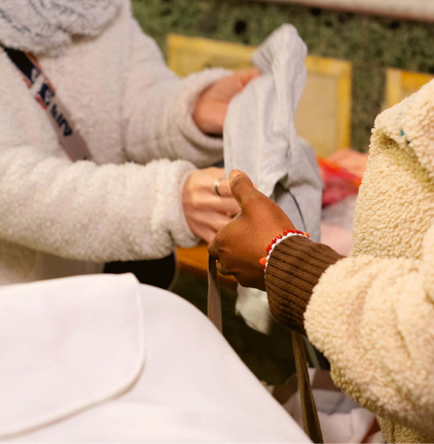 due mani che si passano una borsa, una bianca e una di colore